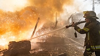 Pazar, 11 Ekim 2026'da Ukrayna'nın Harkiv kentinde Rus saldırısıyla yıkılan konutlarda çıkan yangını bir kurtarma görevlisi söndürüyor.